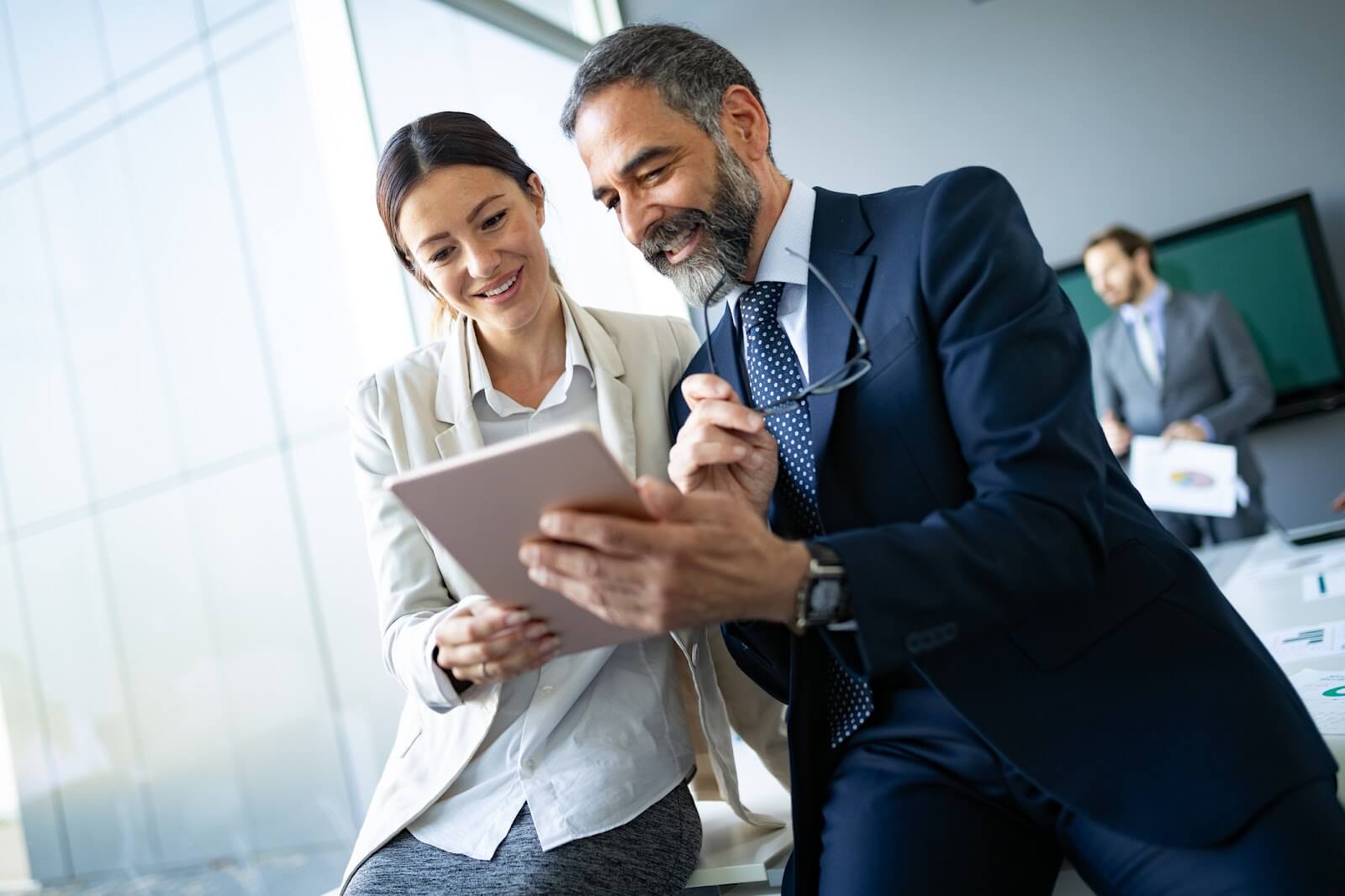 a man and woman looking at something on a tablet.